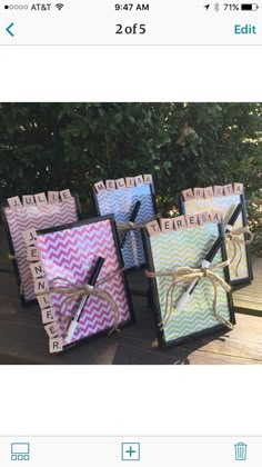 three small boxes with writing on them are sitting on a wooden table next to some trees