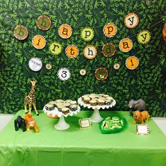 a green table topped with cakes and cupcakes