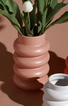 two vases with flowers in them sitting next to each other on a table top