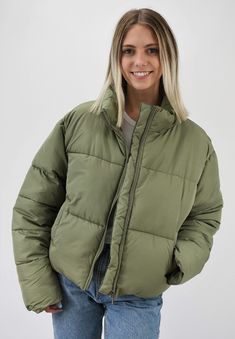 Warm and Fashionable. This cropped puffer jacket adds just the right style to any outfit while keeping you warm. The jacket has a front zipper and pockets to maximize fashion and ease with a back adjustment to cinch the waist for the most flattering fit. Wear this now for those chilly days or on gameday to add just the right color to your outfit. Pairs nicely with Color Fleece Crop. Color-Olive Green (also available in Stone, Blue, Teal, Cheddar Gold, Caramel, Cream, Black, Pale Lavander, Charcoal Blue, Pale Pink, Sky Blue, Hot Pink, Milk Chocolate, Orange, Green, and Lime Green) 80% Polyester 20% Nylon Urban Nylon Puffer Jacket For Spring, Urban Spring Puffer Jacket With Padded Collar, Urban Style Spring Puffer Jacket With Padded Collar, Urban Puffer Jacket With Pockets For Spring, Urban Style Spring Puffer Jacket With Pockets, Nylon Utility Puffer Jacket For Fall, Casual Puffer Quilted Jacket For Streetwear, Casual Quilted Puffer Jacket For Streetwear, Cropped Winter Outerwear With Zipper