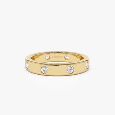 a yellow gold ring with three diamonds on the inside and outside, set against a white background