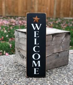 a welcome sign sitting on top of a wooden crate