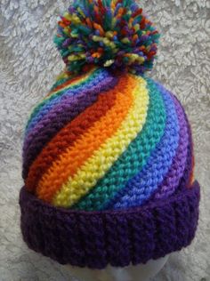 a multicolored knitted hat with a pom - pom on top