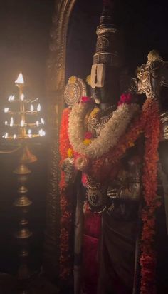 the statue is decorated with flowers and candles