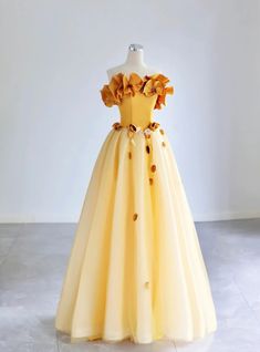 Ornate and breathtaking, this yellow prom dress is designed for those who love to make a statement. The off-the-shoulder bodice is embellished with large, handcrafted floral appliques, adding a unique and romantic touch to the design. The corset-style top cinches at the waist, providing a flattering and secure fit, while the full, tulle skirt creates a dramatic and elegant silhouette. Each layer of the skirt is delicately gathered, ensuring a graceful flow with every movement. Perfect for proms, balls, or any formal event, this dress promises to make you the center of attention. The attention to detail and high-quality materials ensure both beauty and comfort, allowing you to move with ease and confidence. Wear this gown and let its enchanting design transform your special night into an un Belle Prom Dress, Prom Dress Off The Shoulder, Brown Prom Dresses, Yellow Homecoming Dresses, Princess Academy, Tulle Applique, Orange Prom Dresses, Purple Homecoming Dress, Burgundy Homecoming Dresses