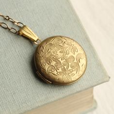 This personalised locket necklace has the most amazing floral leaf engraving! We can professionally insert your photos inside, and engrave your initial on the front in a choice of five beautiful font options. The locket necklace measures 26mm (just over an inch) in diameter. A beautifully understated miniature piece of jewellery that would be ideal for layering with other necklaces, or worn by itself. Our lockets are made to order and we offer a range of different chain lengths. Please refer to Round Bridal Bouquet, Bride Jewelry Set, Engraved Locket, Gold Locket Necklace, Silk Purse, Engraved Flower, Victorian Flowers, Gold Brocade, Necklace Antique