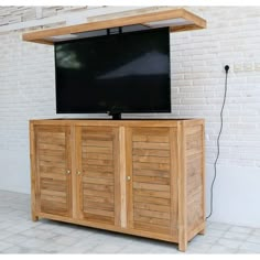 a flat screen tv sitting on top of a wooden cabinet