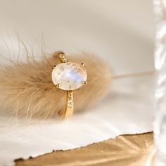 The Moonstone Ring (Serena) features an oval rainbow moonstone set on a gold tapered band. This elegant statement ring is flanked by cubic zirconia stones that shine brilliantly like diamonds. We love this ring because of its intriguing blue and white tones!


The rainbow moonstone measures 10mm x 8mm.
 Size: 4, 5, 6, 7, 8, 9, 10 Gold Moonstone Ring, Silver Rings For Women, Gold Vermeil Jewelry, Trendy Ring, Big Rings, Detailed Ring, Moonstone Jewelry, Cheap Jewelry, Traditional Jewelry