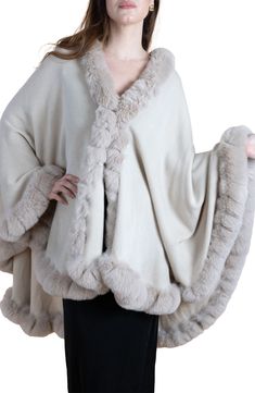 Add a toasty yet glam finish to your elegant ensemble with this draped cape that is trimmed with faux fur. Open front Short sleeves Shell/faux fur: 100% polyester
 Hand wash, line dry Imported Fur Trimmed Cape, Faux Fur Cape, Fur Design, Trim Scarf, Crochet Kimono, Fur Cape, Sequin Pants, Scarf Poncho, Crochet Poncho