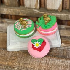 three decorated cupcakes sitting on top of a tray