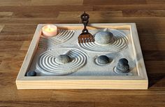 a wooden tray with rocks and a comb on it, sitting on a wood floor