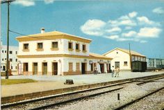 an old photo of a train station with people standing on the platform