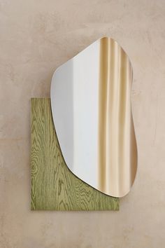 a mirror that is on the wall next to a wood paneled floor and beige walls