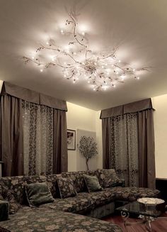 a living room filled with furniture and a chandelier hanging from the ceiling above it