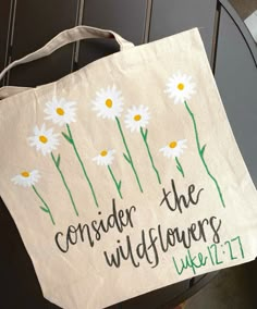 a white bag with daisies on it that says consider the wildflowers week