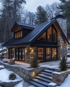 a house that is in the snow with stairs leading up to it and lights on