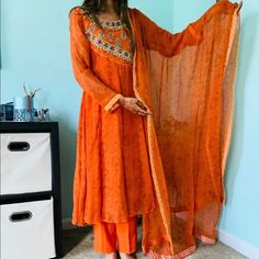 Send Me An Offer, Lets Negotiate Brand New, Never Worn -Orange Angharka Style Shalwar Kameez -Designer Suit! -Chest Size 33 -Stones On Pant Ankle -Green And Purple Threadwork With Stones -3 Pieces: Shalwar, Kurta, And Dupatta -Bandini Border Around Dupatta -Chiffon Fabric Orange Designer Palazzo Set For Navratri, Orange Palazzo Set With Dupatta And Traditional Drape, Traditional Drape Orange Palazzo Set With Dupatta, Semi-stitched Orange Palazzo Set With Zari Work, Orange Palazzo Set With Zari Work And Straight Kurta, Designer Orange Palazzo Set With Zari Work, Orange Semi-stitched Palazzo Set For Navratri, Festive Semi-stitched Palazzo Set In Orange, Orange Bollywood Designer Palazzo Set