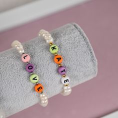 Customized bracelet made of freshwater white pearls and colorful letters. You can use the word/name up till 6 letters. Color of the letters will be picked randomly. Bracelet is stretchable and can be made with metal ball in gold either in silver color. This is a great present for yourself, relatives or friends and personalization will make it extra special.  Material and size: - Freshwater pearls - Plastic cubes with letters - Metal balls made of stainless steel - Length can be customized * As a Personalized Letter Beads Bracelets, Personalized Round Beads Pearl Bracelet For Everyday, Trendy Letter Name Bracelet For Gift, White Beaded Bracelets With Letter Beads For Personalized Gift, Personalized White Beaded Bracelets With Letter Beads, White Custom Name Letter Bracelets, Custom Name White Letter Bracelets, White Letter Beads Bracelet For Birthday, Trendy Beaded Bracelets With Letter Print For Gift