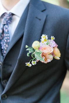 a man wearing a suit and tie with flowers in his lapel flower bouquet on his lapel