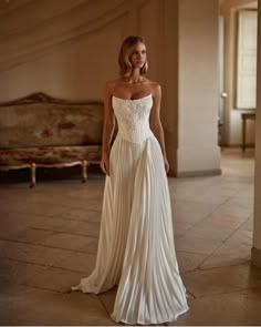 a woman in a white dress is posing for the camera