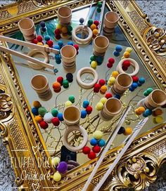 an elaborately decorated mirror with colorful balls and needles in the middle, surrounded by other objects