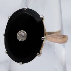 This antique Victorian 18k gold ring features a gorgeous large, faceted onyx adorned with a lovely Old European Cut 2.5mm diamond center. The stone is set with a 6-pronged, platinum tipped, triangle cut out gallery. This ring is a size 6, weighs 3.5 grams and measures 17mm tall. It is in excellent antique condition with light wear and is not marked but has been tested and is guaranteed. Classic Black Jewelry With Single Diamond, Black Ring With Single Diamond In Fine Jewelry Style, Black Ring With Single Diamond, Timeless Black Rings With Rose Cut Diamonds, Elegant Black Ring With Single Diamond, Timeless Black Ring With Rose Cut Diamonds, Classic Onyx Diamond Ring, Vintage Black Diamond Round Ring, Classic Black Ring With Single Diamond