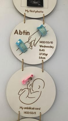 two signs hanging from the side of a wall with baby's birth pictures on them