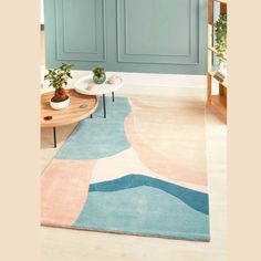 a living room with blue, pink and white rugs on the floor next to a coffee table