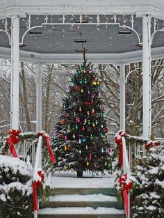 a decorated christmas tree in the middle of a gazebo