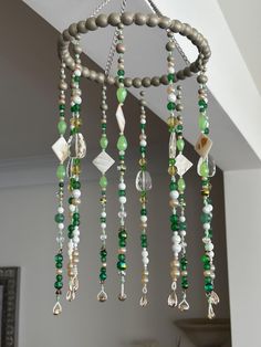 a wind chime hanging from the ceiling with beads and stones on it's sides