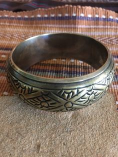 Vintage brass bracelet has silver plating on inside and over edge. Beautiful tribal design will look nice to offset black attire or blend well with Southwest or other ethnic clothes. Inside of bangle measures 8 inches around. It is 1 1/4 inch wide and about 1/2 inch high. A fun boho vintage bracelet. Would make an unique gift. Metal Bangle With Intricate Design For Festival, Brass Bracelets With Intricate Design For Festivals, Gold Bohemian Bracelets For Rituals, Bohemian Antique Gold Brass Bracelets, Engraved Metal Bangle For Festivals, Brass Bangle For Festival, Brass Bangle Jewelry For Festival, Metal Round Bangle For Festival, Bronze Brass Bracelets With Intricate Design