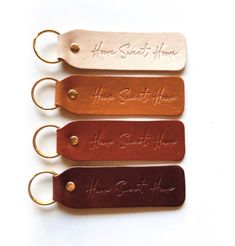 four leather keychains with the words home sweet home on them