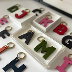 the letters are in different colors and shapes on display with key chains attached to them