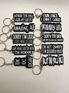 six keychains with different types of words on them, all in black and white