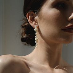 Our gorgeous Amelie Pearl Drop Earrings are hand assembled with freshwater pearls to create an undeniably elegant, minimal, and modern vibe. Perfect for any bridal affair, these asymmetrical earrings make for a tasteful and modern look. With its organic pearls, the Amelie Pearl Drop Earrings will give you a timeless and minimal style fit for all of your special occasions. Gold plate over brass Freshwater pearl fringe accents Hand-crafted and assembled Lightweight 1.5" in length Nickel- and lead- Graceful Pearl Earrings With Pearl Charm, Minimalist Formal Bridal Earrings In Pearl White, Modern Pearl Earrings For Evening, Minimalist Pearl Pendant Earrings For Wedding, Modern Akoya Pearl Drop Earrings, Modern White Akoya Pearl Earrings, Modern Pearl White Earrings With Pearl Drop, Modern Pearl White Earrings With Pearl Charm, Pearl White Pearl Drop Linear Earrings