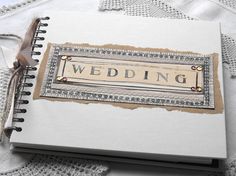 a wedding book is sitting on a lace covered tablecloth with the words'wedding'written in it