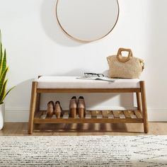 a wooden bench sitting next to a potted plant on top of a hard wood floor