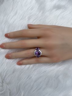 The key stone of this ring is a 11x9mm natural amethysts, and the main material of this ring is sterling silver plated with 18k white gold. On each side of the main stone are one 5x3mm and two 5x2.5mm amethysts. The small accent stones and zircon emphasize the big size of the key stone. Amethyst is a birthstone for February, and the color purple is meant to bring wealth and royalty. Also, many people believe amethyst has the power to relieve stress and purify the mind. Size: Adjustable and fitab Fine Jewelry Cluster Ring With Gemstone, Elegant Amethyst And Cubic Zirconia Promise Ring, Fine Jewelry Crystal Ring With Accent Stones, Anniversary Cubic Zirconia Crystal Ring With Gemstone, Exquisite Cubic Zirconia Cluster Ring With Gemstone, Fine Jewelry Pear-shaped Crystal Ring For Anniversary, Fine Jewelry Crystal Open Ring For Anniversary, Fine Jewelry Cubic Zirconia Gemstone Rings, Elegant Amethyst Cubic Zirconia Ring