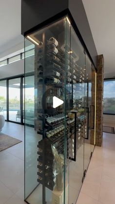 a glass wine cellar in the middle of a living room