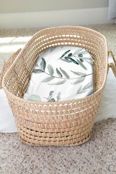 a wicker basket sitting on the floor next to a pillow