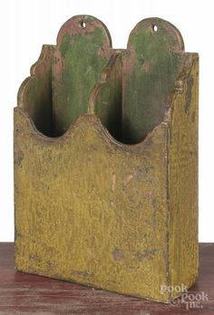 an old wooden holder with three green planters in it on top of a table