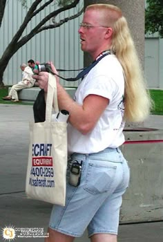 a man is holding a bag and looking at his cell phone