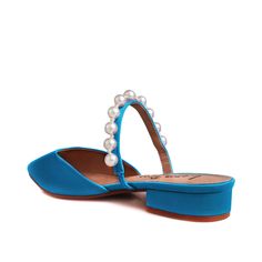 a pair of blue shoes with pearls on the toes