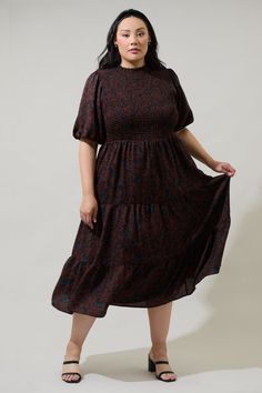 The Kalida Beau Frazier Smocked Tiered Midi Dress is reminding us of all the reasons to feel gratitude. Full, short puff sleeves frame a flattering smocked bodice that tops a flowy, tiered midi skirt. A keyhole sits at the top of the back to make getting in and out easier. Wear it to any event with your favorite accessories and boots to complement the look.- Smocked- Keyhole- Tiered- Bubble sleeves- Color: ChocolateSize + Fit - Model is 5'9" and wearing size 2X- Measurements taken from size 2X - Flowy Smocked Dress With Short Elastic Sleeves, Brown Dress With Smocked Bodice And Short Sleeves, Brown Short Sleeve Dress With Smocked Bodice, Flowy Smocked Dress With Short Sleeves And Smocked Cuffs, Billowy Smocked Dress With Short Sleeves, Fall Smocked Dress With Short Sleeves, Modest Smocked Ruched Short Sleeve Dress, Brown Smocked Bodice Dress, Midi Length, Flowy Brown Smocked Dress With Smocked Bodice