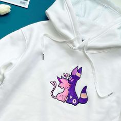 Introducing our Umbreon Espeon Embroidered Hoodie, the perfect gift for Christmas, birthdays, and Valentine’s Day! This premium hoodie boasts exquisite embroidery of these iconic Pokémon, adding a touch of style to your wardrobe. Made with high-quality materials, it offers exceptional comfort and durability. Stay warm and cozy while showcasing your love for Pokémon! Ideal for any fan, this hoodie is a must-have collectible, making it a valuable addition to your wardrobe. Embrace your inner Umbreon Espeon, Umbreon And Espeon, Embroidered Hoodie, Embroidered Sweatshirts, Gift For Christmas, Embroidered Shirt, Perfect Christmas, Christmas Birthday, Hoodie Sweatshirt