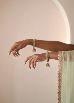 Adorn your wrists with the refined elegance of our antique gold Saavana Bangles, featuring almond-shaped gems and cream stones. The dangling jhumkas add a touch of sophistication, perfect for standalone chic or curated bangle ensembles. Includes 2 bangles. Indian Jewelry Photography, Indian Jewelry Aesthetic, Jhumka Bangles, Indian Wedding Bangles, Gold Kangan, Desi Jewelry, Beautiful Bangles, Cream Stone, India Shopping