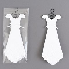 two pieces of paper with clothes on hangers attached to the back of each piece