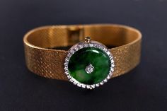 "Fine watch bracelet set with a jade donut and accented with diamonds in 18k. The donut is a deep green Omphacite jade, in parts dark and light like a globe lit. This jewel borrows the perfect finish of a Vacheron watch, its Omega straps in original burnished solid gold. More than a conversion piece, this bracelet could not have been refined to a sleeker layout. At 2cm, the donut is considered big yet its size is offset by the straps, and vice versa. The straps though wide feel made for its cent Elegant Formal Jade Jewelry, Fine Jade Jewelry For Formal Occasions, Formal Round Jade Jewelry, Timeless Green Jewelry For Evening, Timeless Green Evening Jewelry, Green Polished Jewelry For Evening, Polished Green Jewelry For Evening, Green Polished Evening Jewelry, Green Polished Finish Evening Jewelry