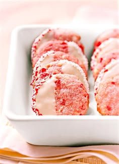 a white dish filled with pastries covered in powdered sugar and sprinkles