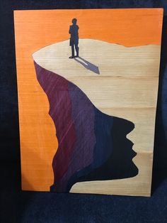 a piece of art depicting a person standing on top of a cliff in the desert